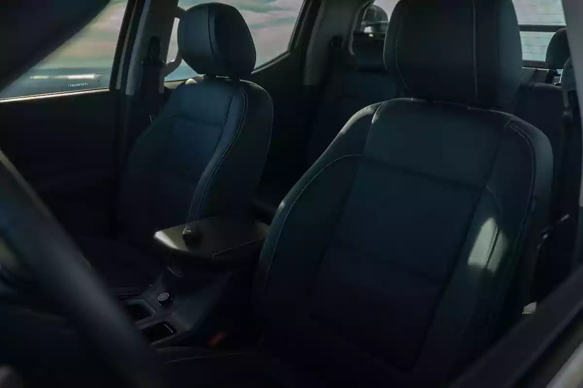 Asientos delanteros de un automóvil con tapicería de cuero negro y costuras visibles