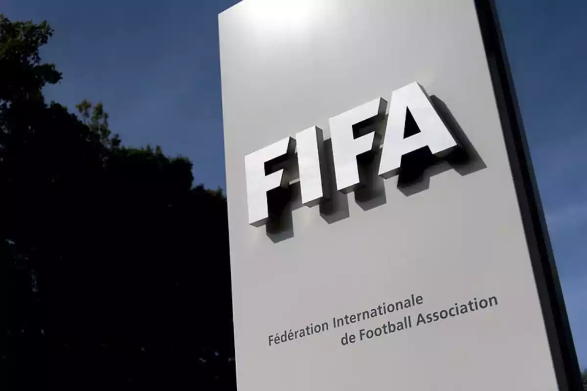 Letrero de la FIFA en un fondo azul con árboles al lado izquierdo Letrero de la FIFA en un fondo azul con árboles al lado izquierdo
