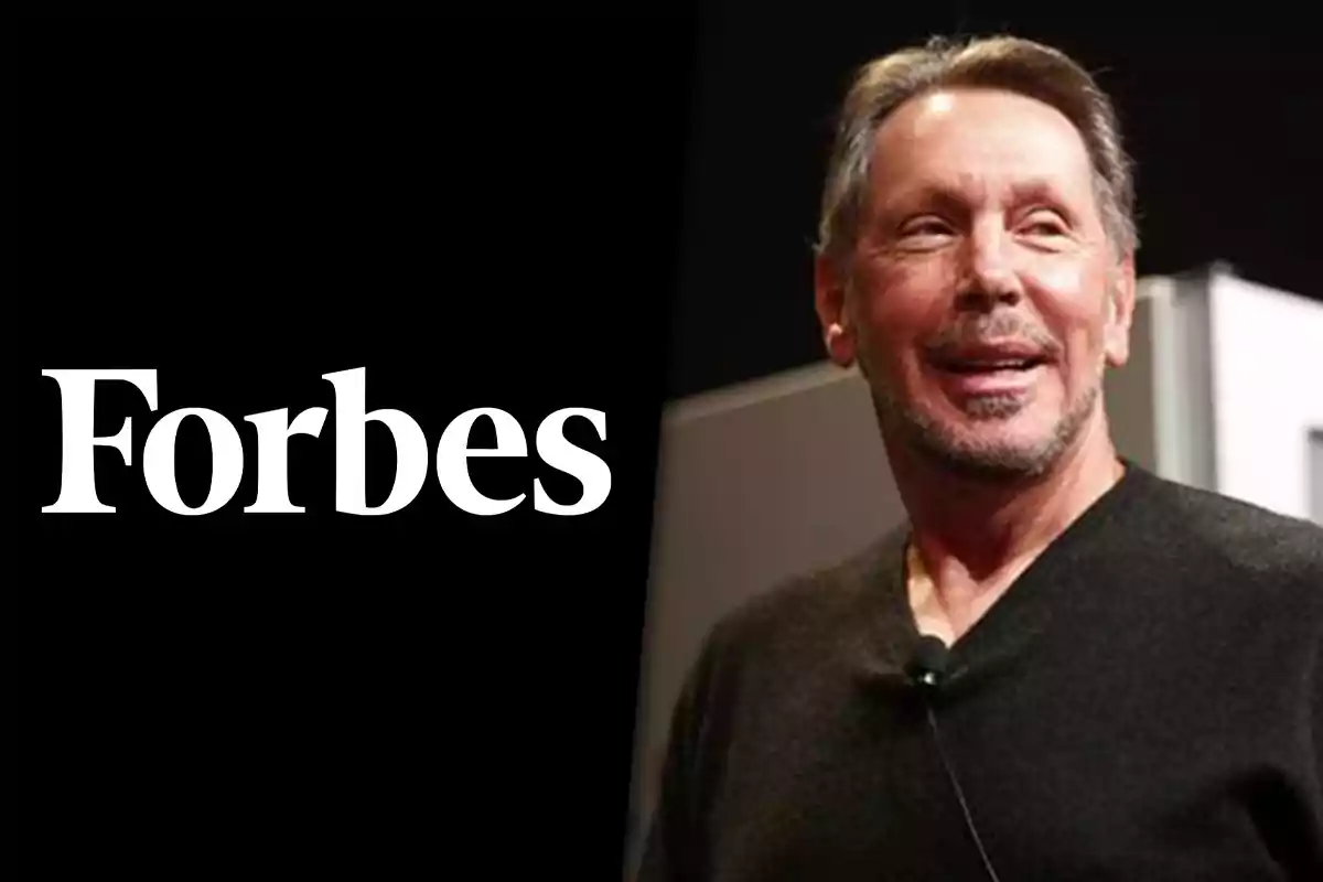 Hombre sonriente con barba y suéter oscuro junto al logo de Forbes sobre fondo negro