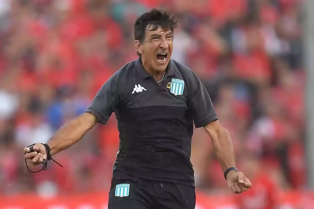 Entrenador de fútbol celebrando efusivamente en la cancha con uniforme de Racing Club y fondo desenfocado de público Entrenador de fútbol celebrando efusivamente en la cancha con uniforme de Racing Club y fondo desenfocado de público