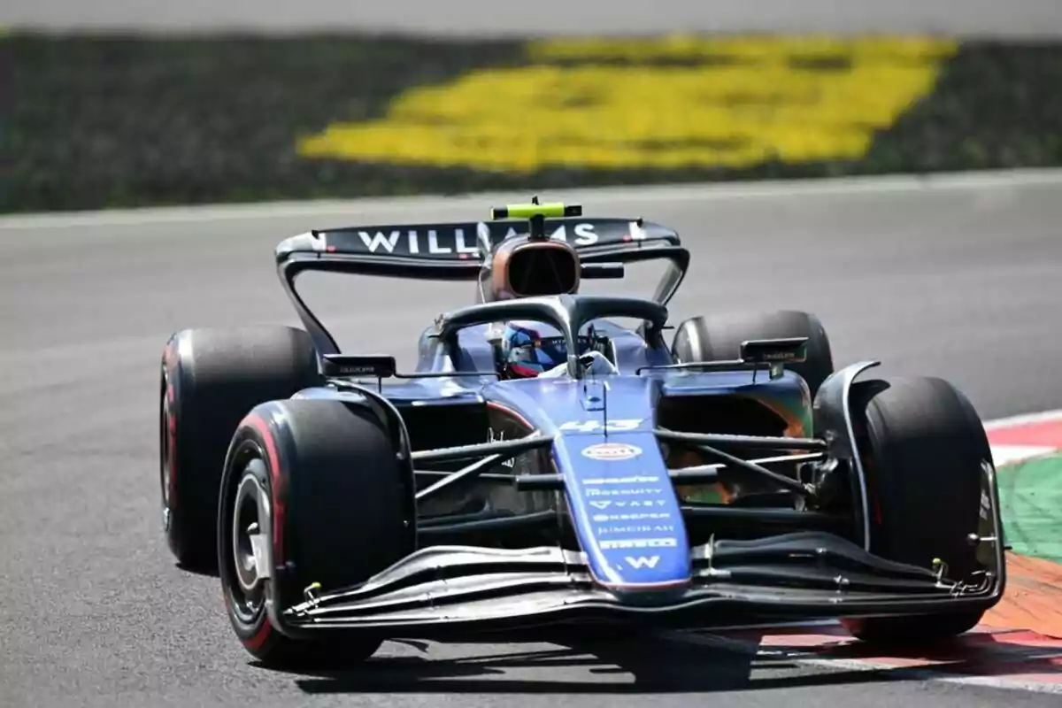 Un monoplaza de Fórmula 1 del equipo Williams toma una curva en un circuito de carreras Un monoplaza de Fórmula 1 del equipo Williams toma una curva en un circuito de carreras