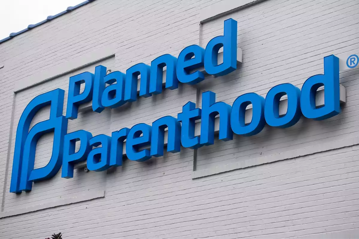 Blue Planned Parenthood sign on the facade of a white building Blue Planned Parenthood sign on the facade of a white building