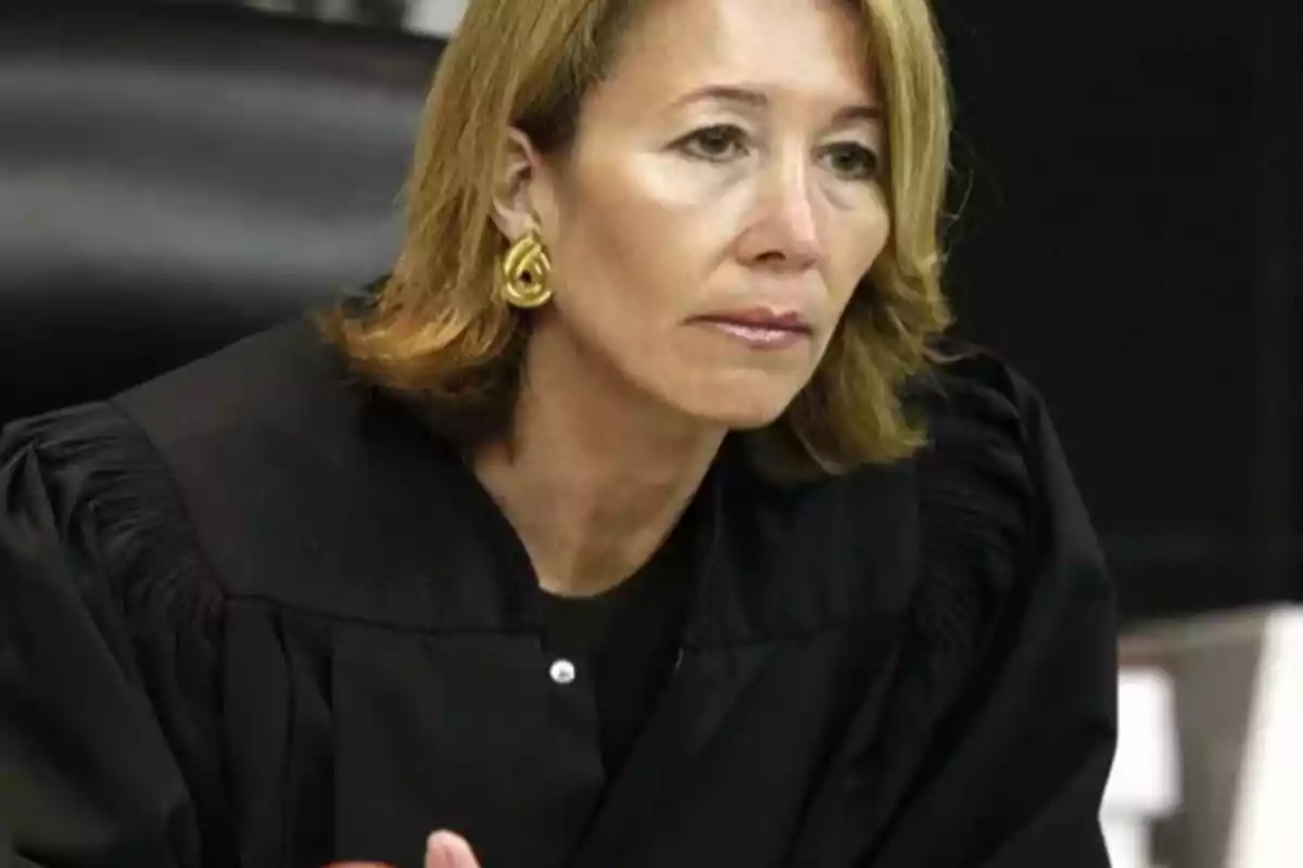 Mujer con toga negra de jueza sentada en una sala de audiencias