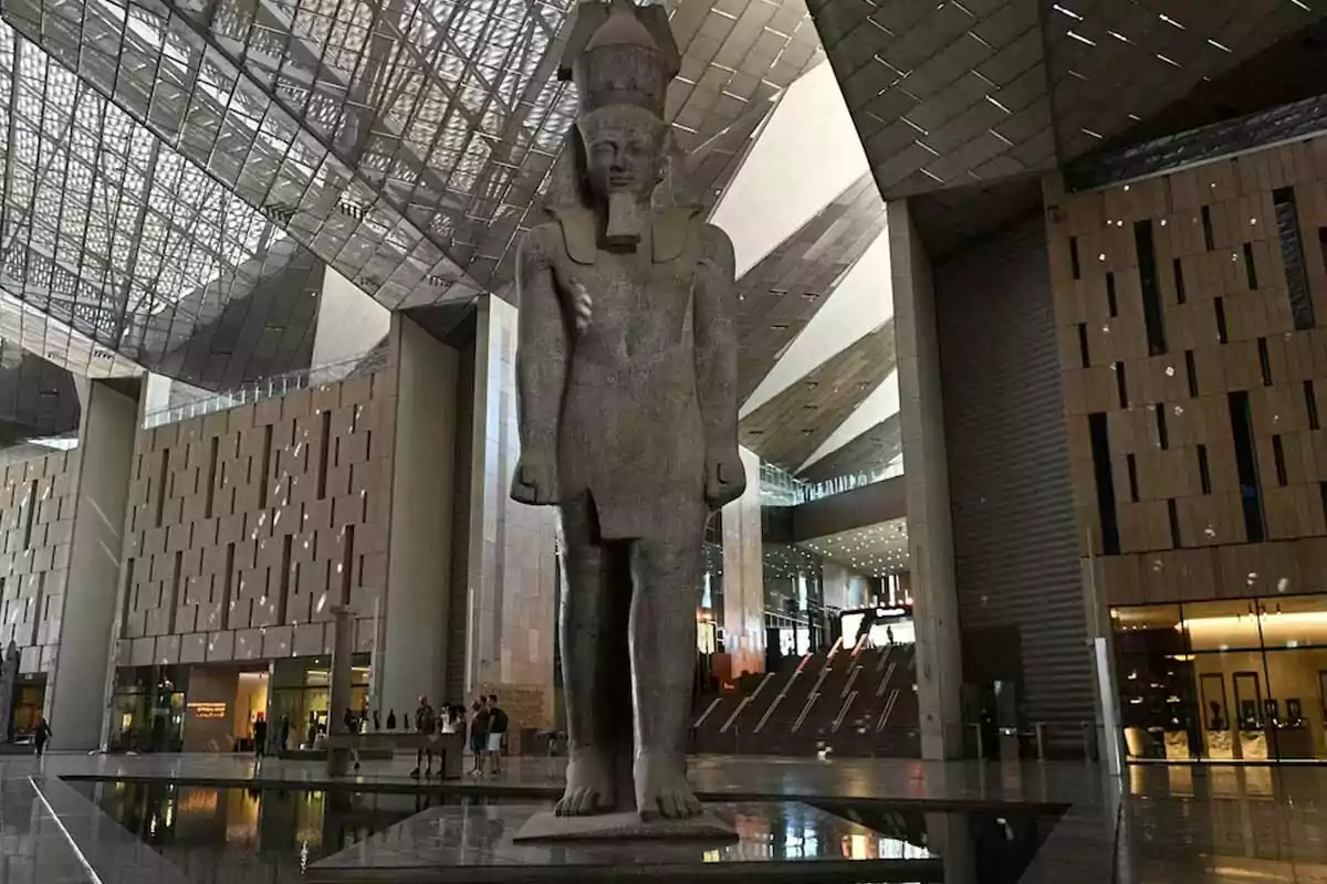 Monumental statue of an Egyptian pharaoh in the lobby of a modern museum with a glass ceiling and wooden walls Monumental statue of an Egyptian pharaoh in the lobby of a modern museum with a glass ceiling and wooden walls