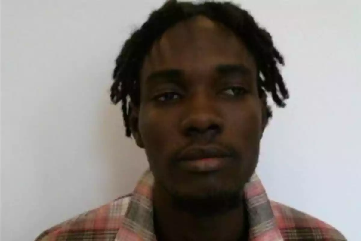 Short-haired man with dreadlocks and a short beard wearing a plaid jersey in front of a white background Short-haired man with dreadlocks and a short beard wearing a plaid jersey in front of a white background