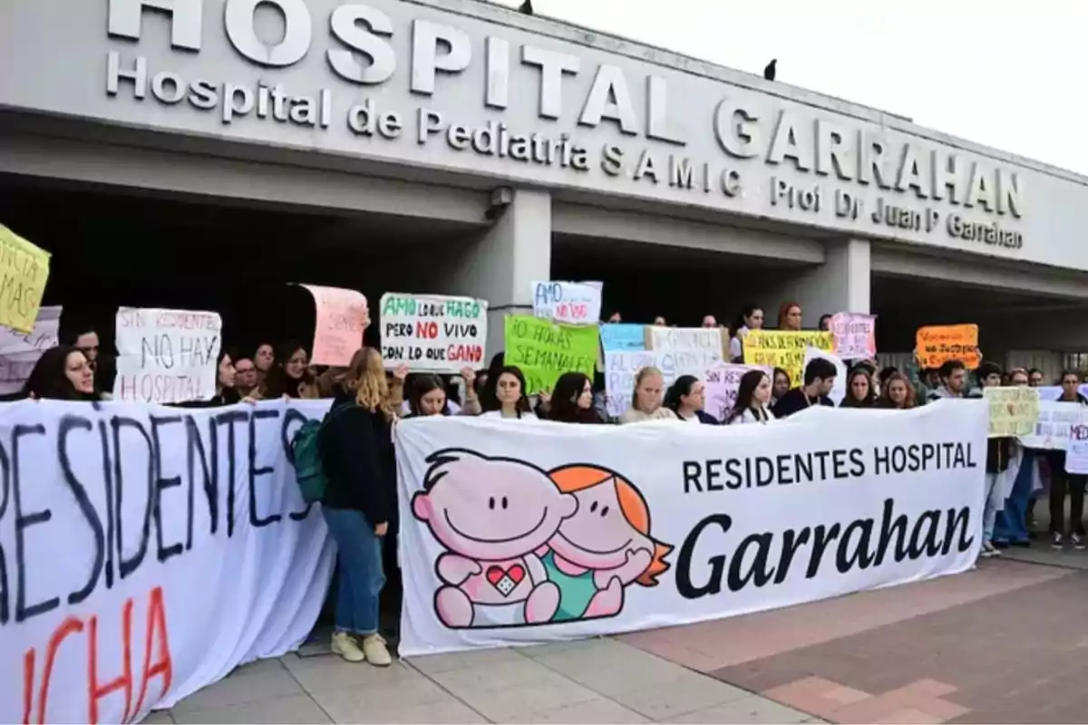 A group of people hold signs and a large flag in front of the entrance to Garrahan Hospital during a protest by medical residents. A group of people hold signs and a large flag in front of the entrance to Garrahan Hospital during a protest by medical residents.