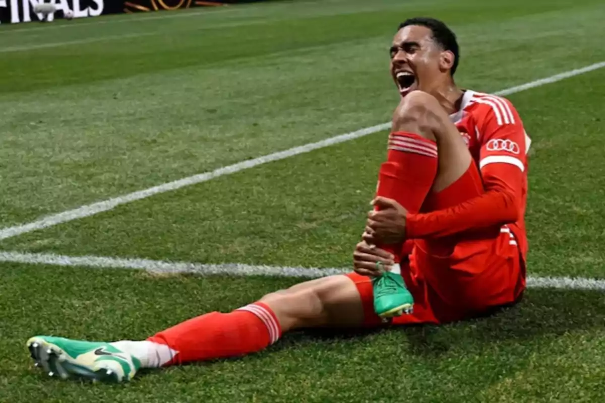 Soccer player sitting on the grass holding his leg with a pained expression Soccer player sitting on the grass holding his leg with a pained expression