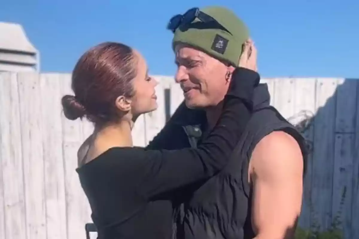 Una pareja se mira de cerca y sonríe mientras se abrazan al aire libre en un día soleado Una pareja se mira de cerca y sonríe mientras se abrazan al aire libre en un día soleado