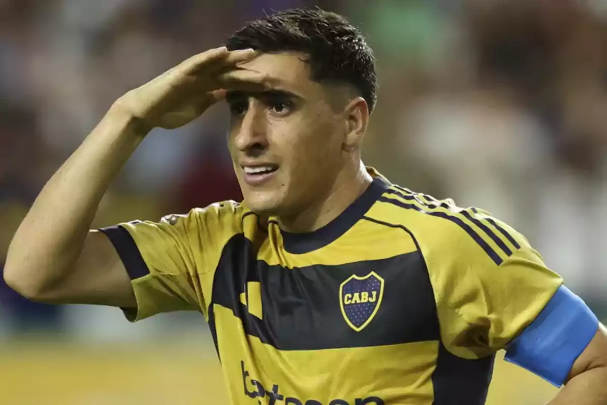 Futbolista con uniforme amarillo y azul de Boca Juniors haciendo un gesto de saludo militar durante un partido