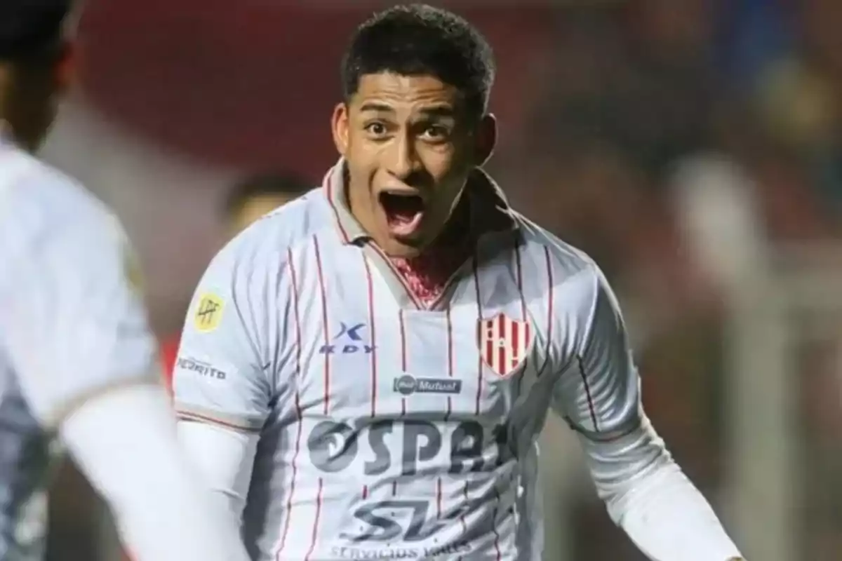 Futbolista con uniforme blanco y rojo celebrando efusivamente en un partido Futbolista con uniforme blanco y rojo celebrando efusivamente en un partido