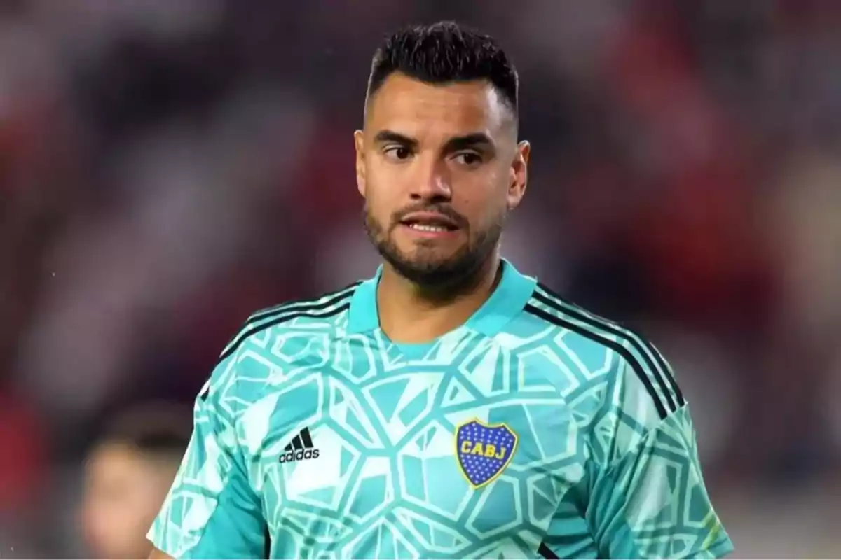 Portero de fútbol vistiendo un uniforme celeste con el escudo de Boca Juniors y fondo desenfocado de estadio. Portero de fútbol vistiendo un uniforme celeste con el escudo de Boca Juniors y fondo desenfocado de estadio.