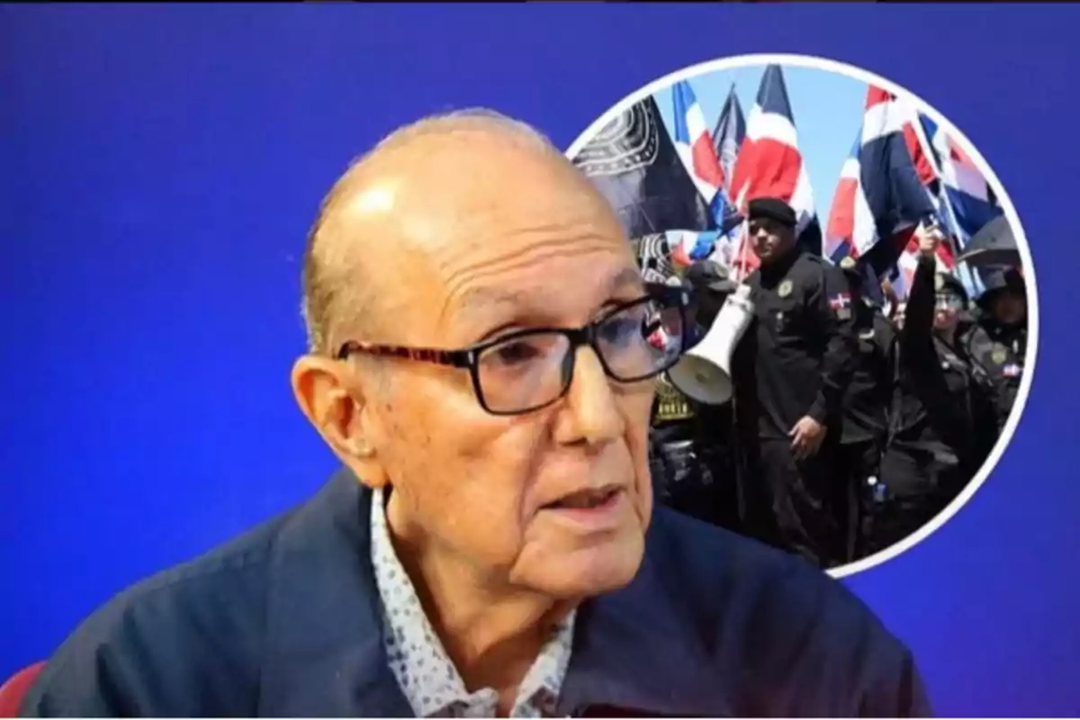 Hombre mayor con gafas en primer plano y al fondo un grupo de personas vestidas de negro con banderas dominicanas
