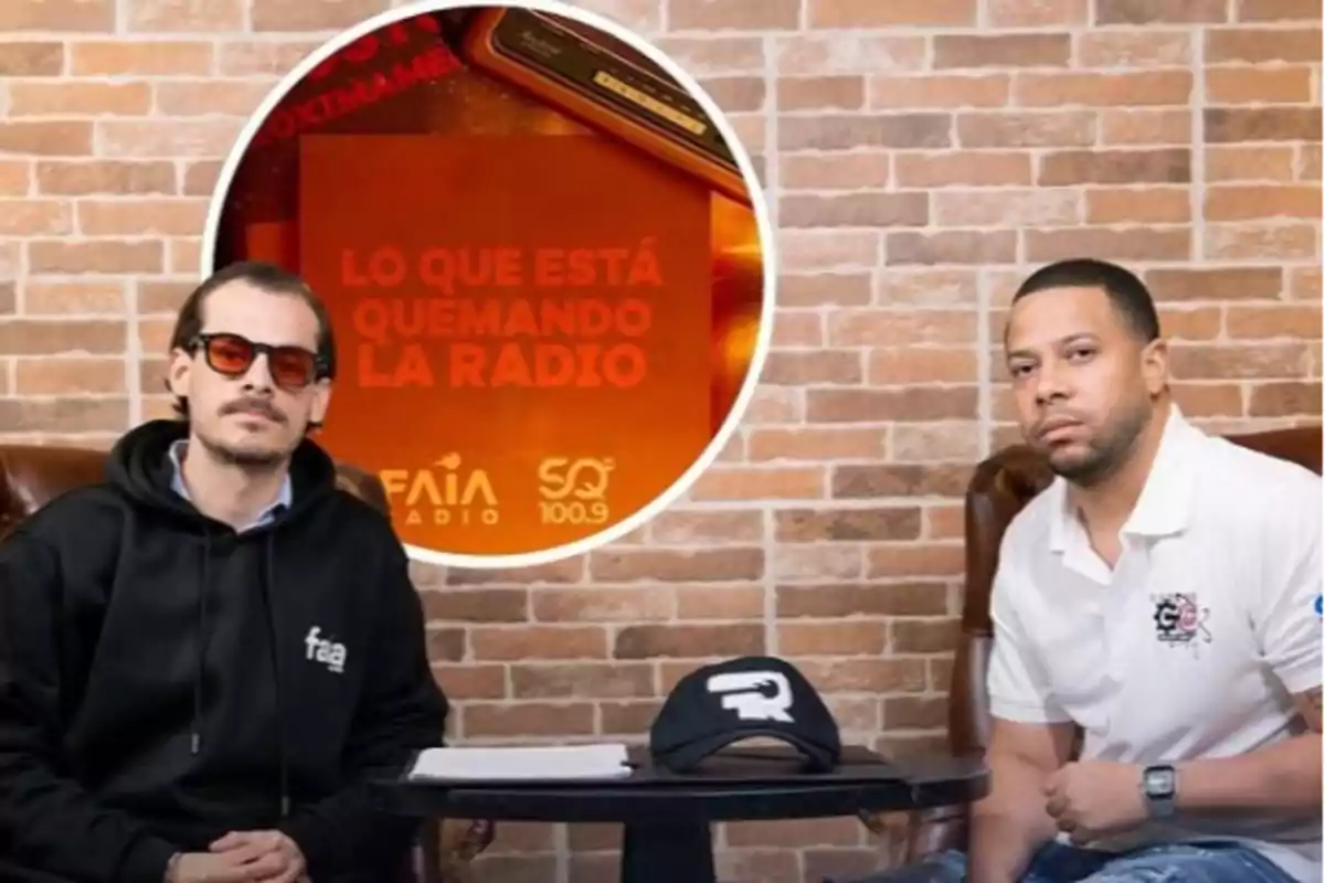 Dos hombres sentados en sillones frente a una mesa con una gorra negra, al fondo una pared de ladrillos y un cartel naranja que dice lo que está quemando la radio