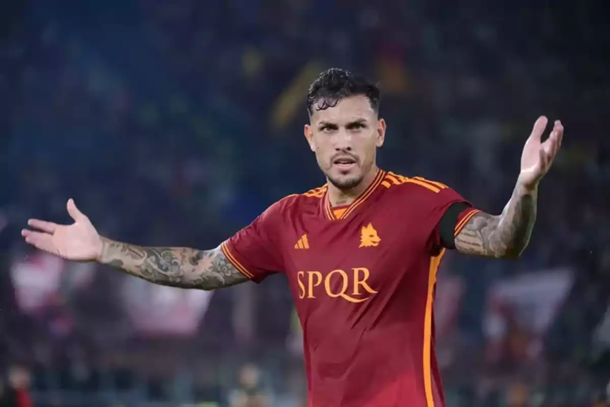 Soccer player in a red and yellow Roma uniform gesturing with open arms in a stadium Soccer player in a red and yellow Roma uniform gesturing with open arms in a stadium
