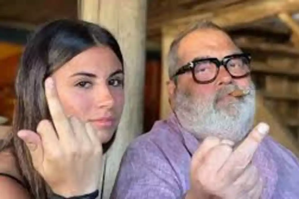 Two people looking at the camera making an offensive hand gesture.