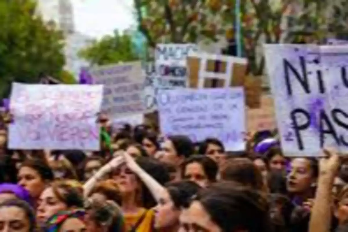 Women marching with signs at a feminist protest Women marching with signs at a feminist protest