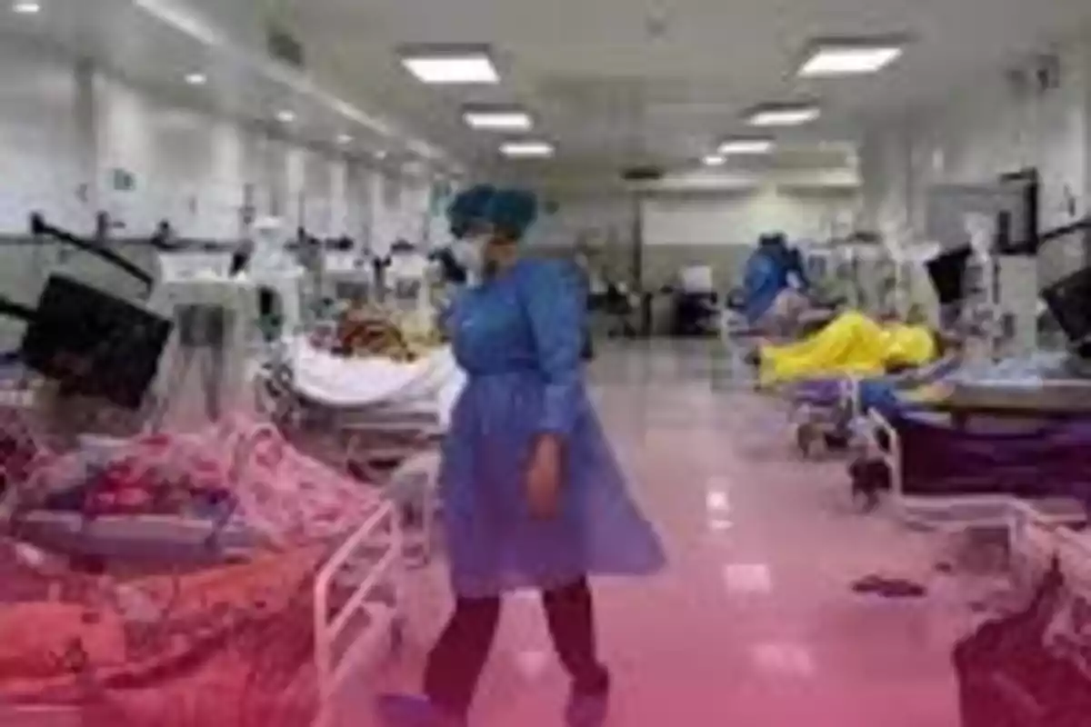 Personal médico con bata y mascarilla camina por una sala de hospital llena de camas y pacientes conectados a monitores Personal médico con bata y mascarilla camina por una sala de hospital llena de camas y pacientes conectados a monitores