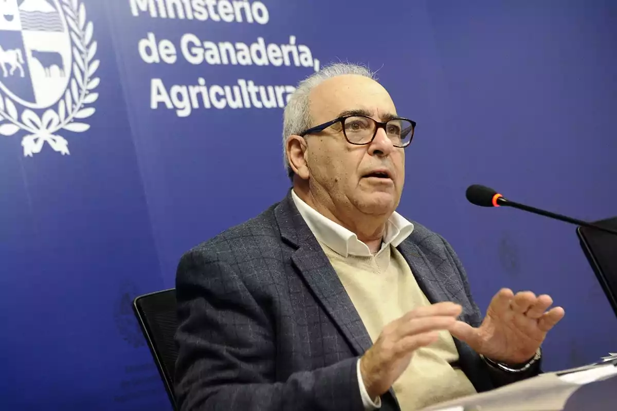 Hombre mayor con gafas hablando frente a un micrófono en una conferencia de prensa en el Ministerio de Ganadería, Agricultura y Pesca