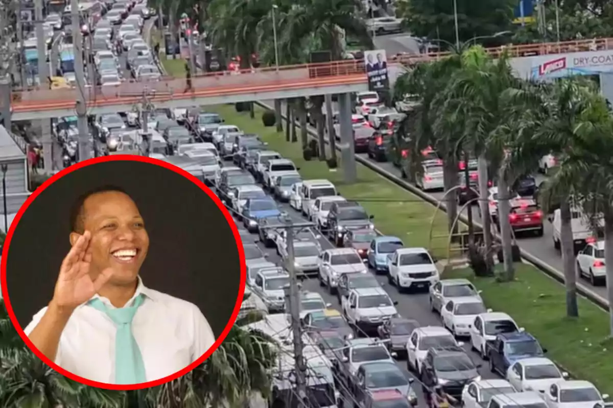 Vista aérea de una avenida con tráfico intenso y una fila de autos detenidos, en la esquina inferior izquierda aparece un hombre sonriente saludando dentro de un círculo rojo