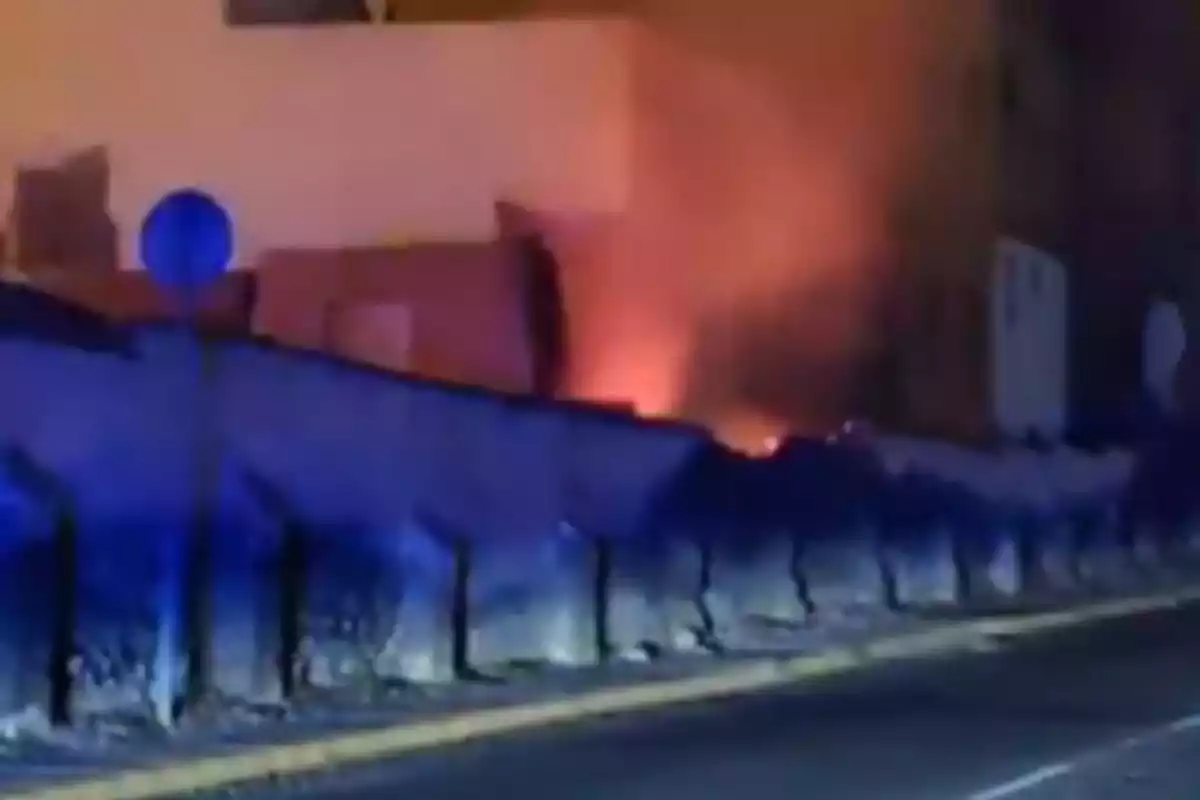 Fire behind a fence in an urban area at night