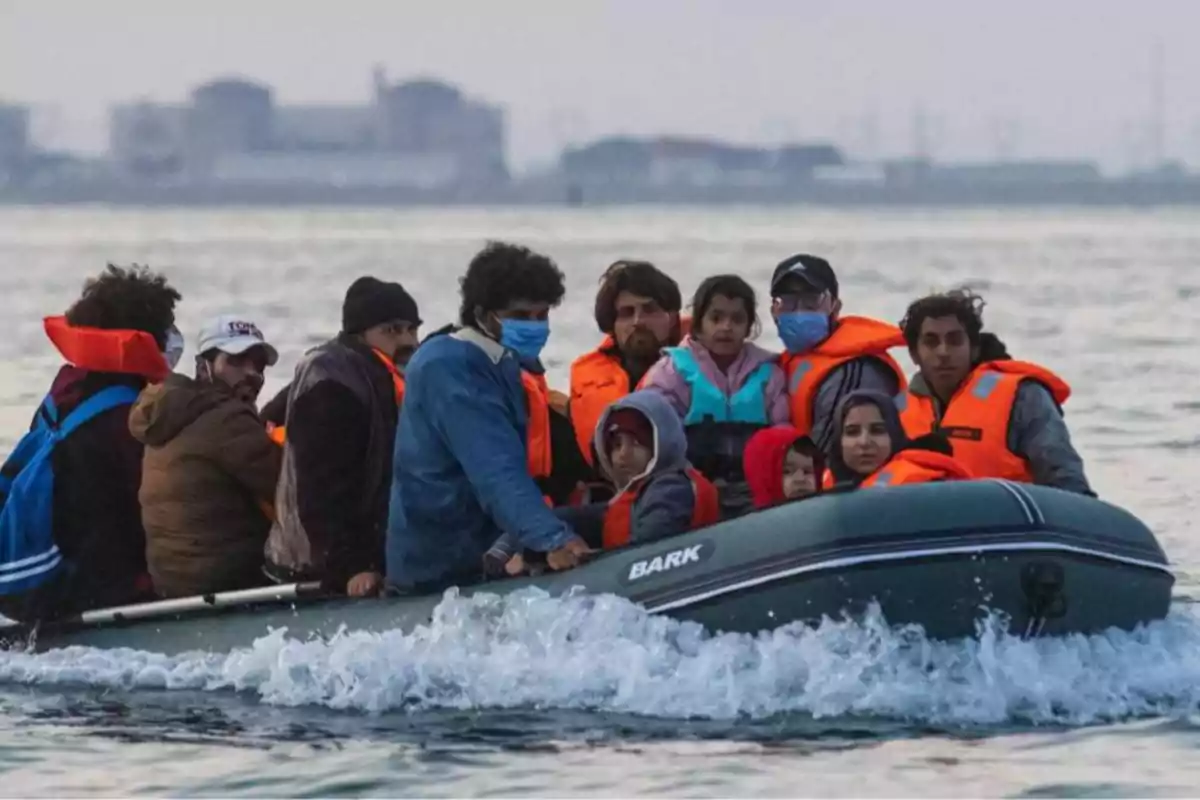 Un grupo de personas con chalecos salvavidas viaja en una lancha inflable sobre el mar Un grupo de personas con chalecos salvavidas viaja en una lancha inflable sobre el mar