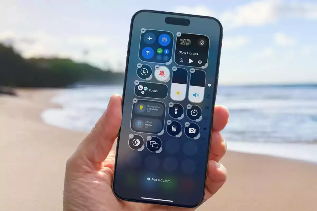 Persona sosteniendo un teléfono inteligente con la pantalla del centro de control abierta en una playa con el mar de fondo Persona sosteniendo un teléfono inteligente con la pantalla del centro de control abierta en una playa con el mar de fondo