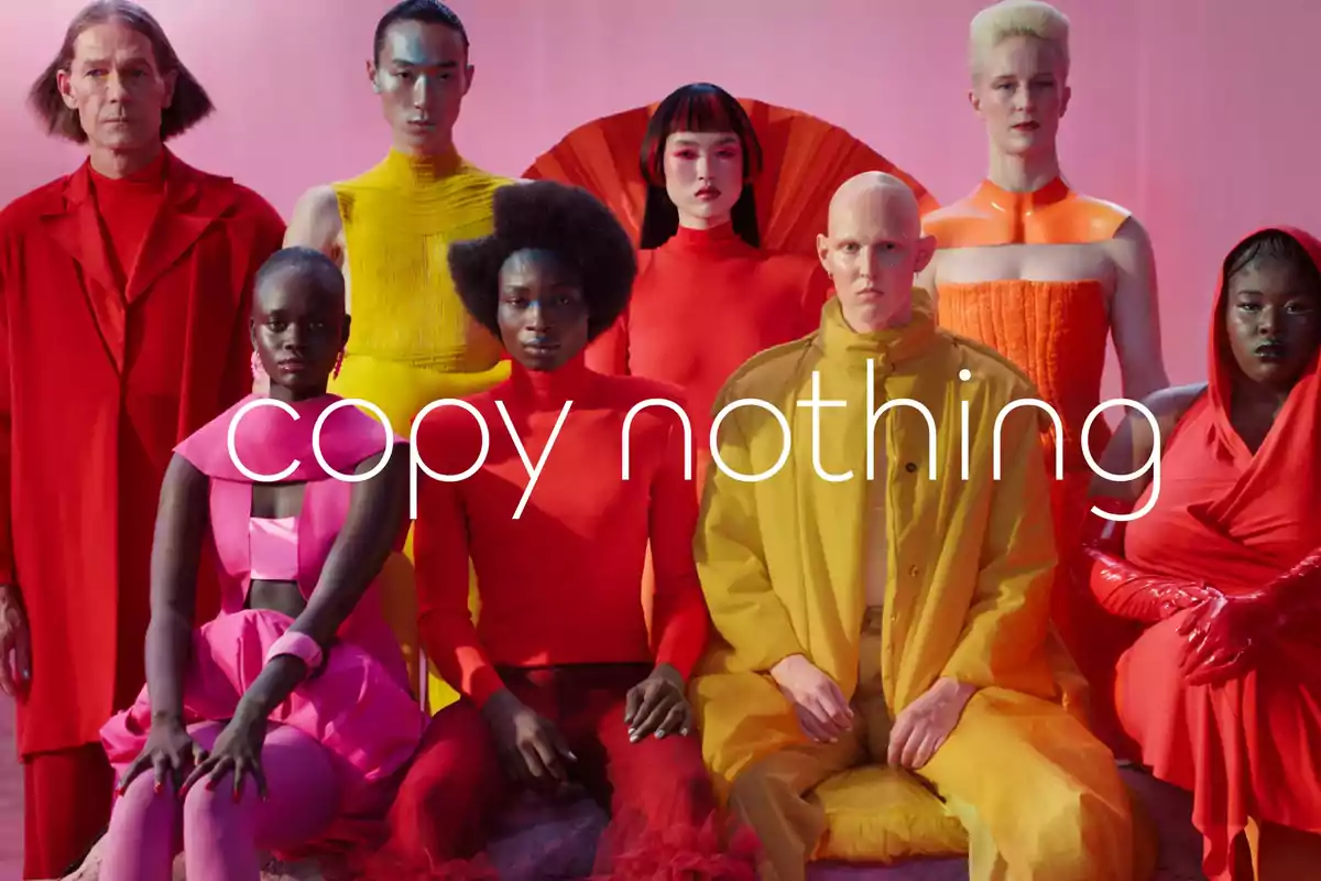 Group of people in colorful, modern clothing posing in front of a pink background with the phrase Group of people in colorful, modern clothing posing in front of a pink background with the phrase