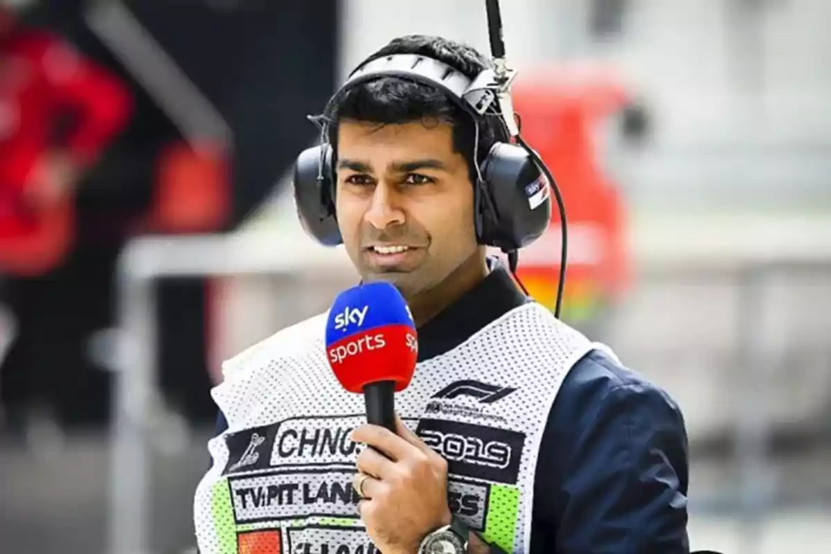 Hombre con auriculares grandes y chaleco de prensa sosteniendo un micrófono de Sky Sports en un entorno de automovilismo Hombre con auriculares grandes y chaleco de prensa sosteniendo un micrófono de Sky Sports en un entorno de automovilismo