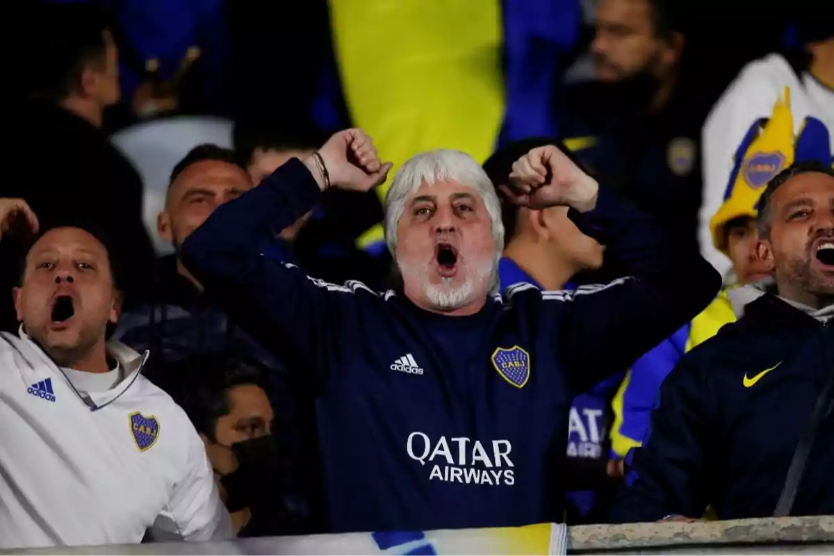 Aficionados de Boca Juniors animando con entusiasmo en las gradas durante un partido de fútbol Aficionados de Boca Juniors animando con entusiasmo en las gradas durante un partido de fútbol