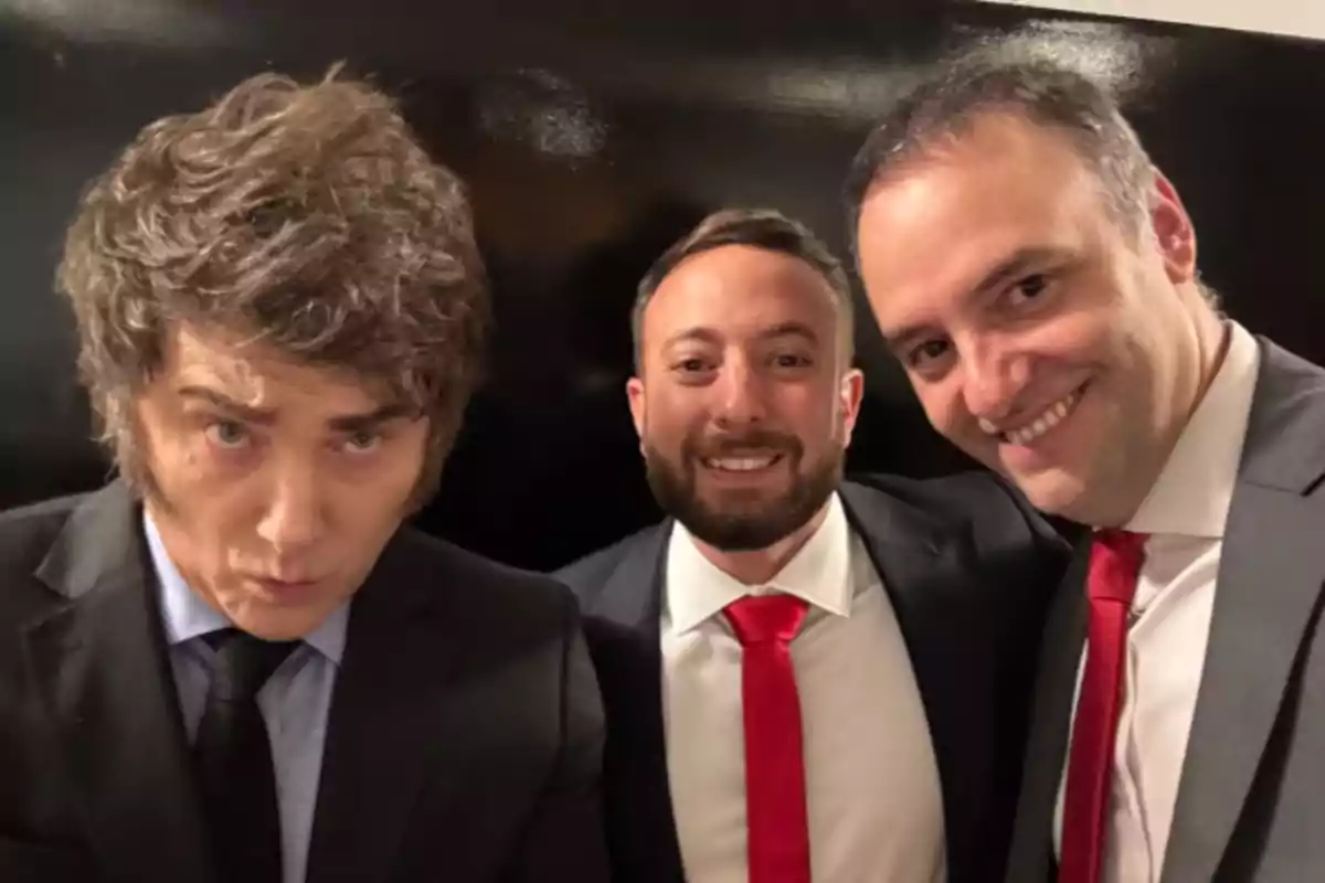 Tres hombres vestidos con traje y corbata posan juntos y sonríen frente a la cámara Tres hombres vestidos con traje y corbata posan juntos y sonríen frente a la cámara
