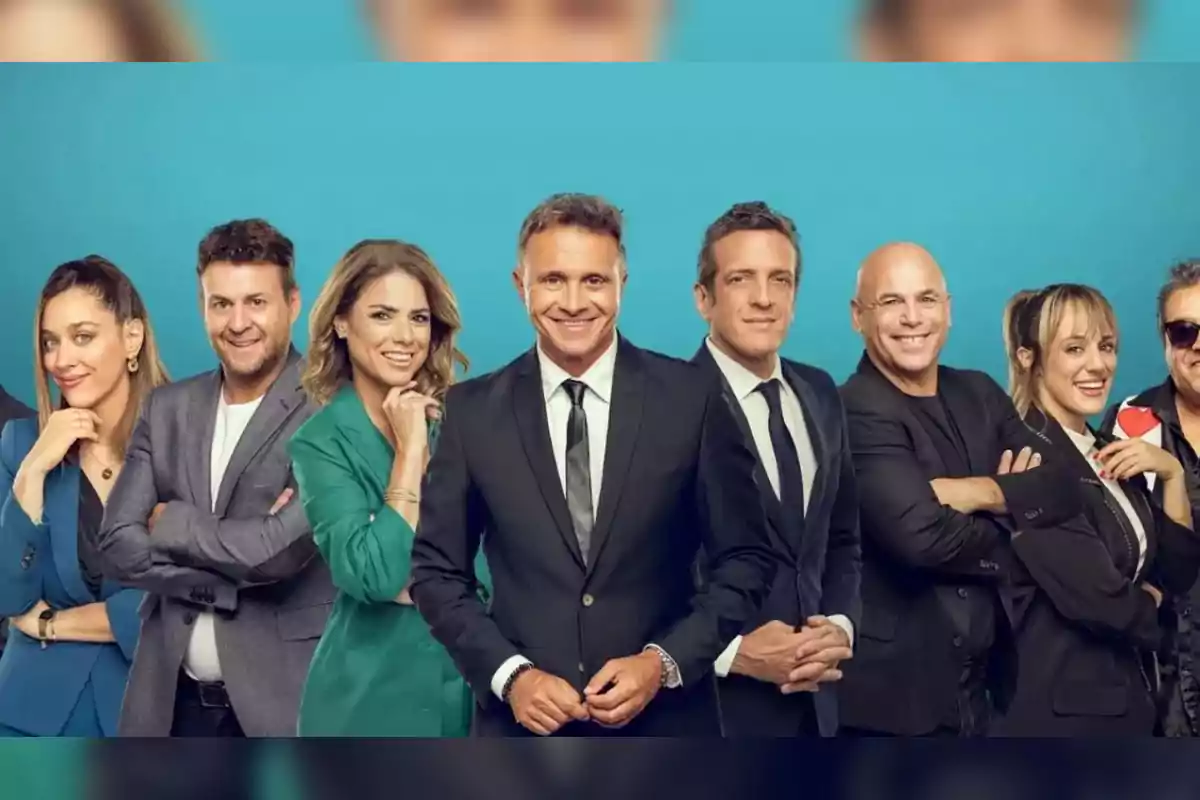 Grupo de personas posando sonrientes frente a un fondo azul, vestidas de manera formal y elegante