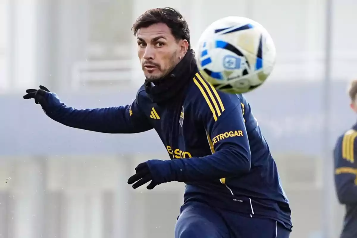 Soccer player in a blue and yellow uniform training while watching a ball in the air Soccer player in a blue and yellow uniform training while watching a ball in the air