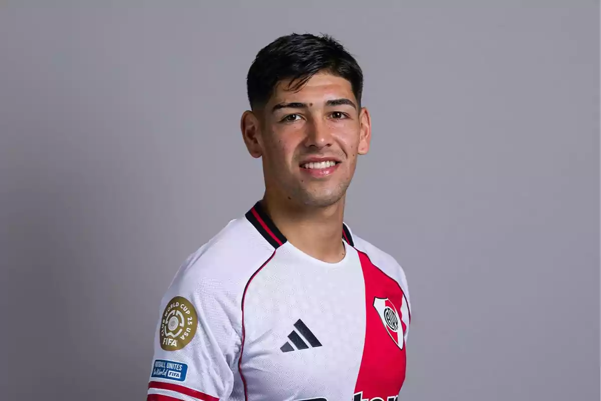 Soccer player wearing a white and red River Plate jersey posing in front of a gray background Soccer player wearing a white and red River Plate jersey posing in front of a gray background