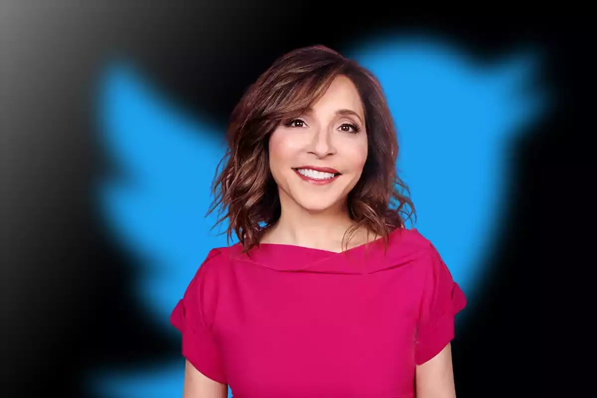 Mujer sonriente con cabello castaño y vestido rosa frente al logo azul de Twitter sobre fondo oscuro Mujer sonriente con cabello castaño y vestido rosa frente al logo azul de Twitter sobre fondo oscuro