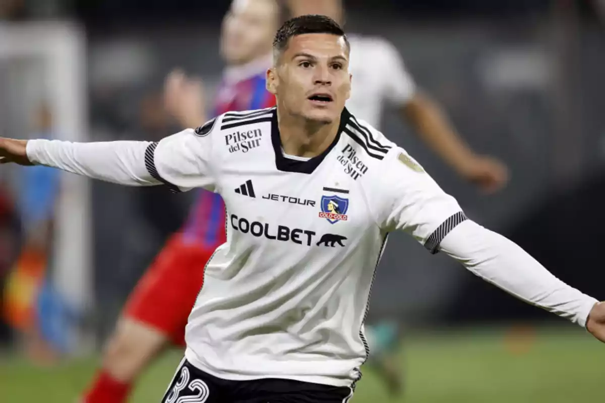 Futbolista con uniforme blanco de Colo Colo celebrando un gol en un partido