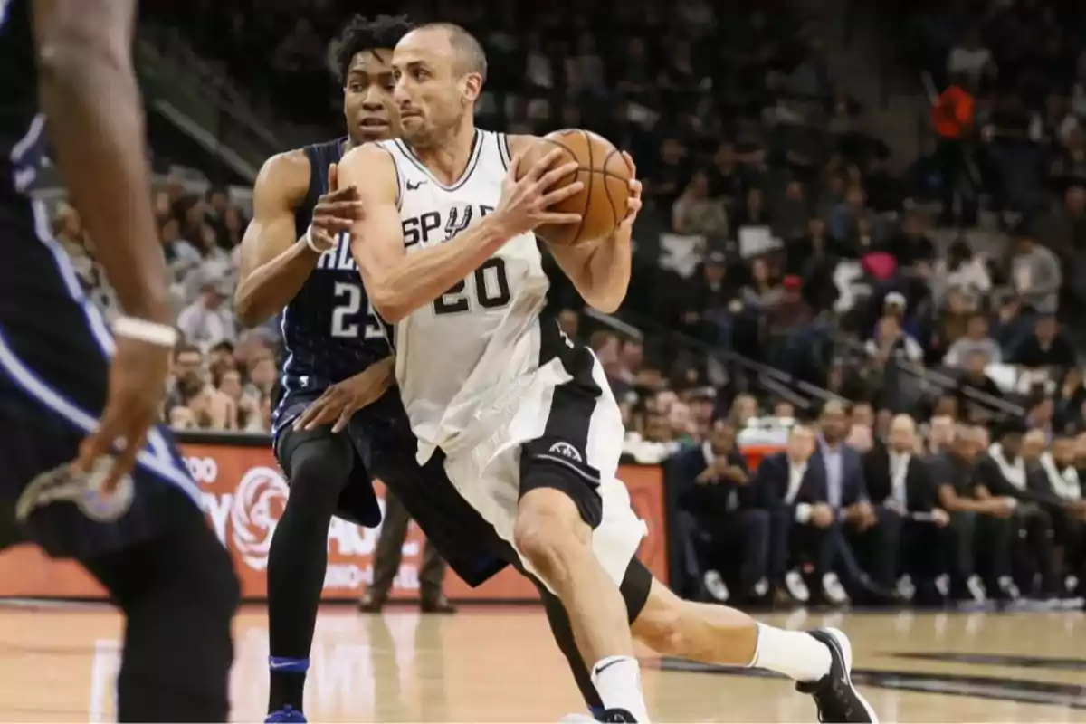 Spurs player dribbles the ball while being guarded by an opponent during a professional basketball game. Spurs player dribbles the ball while being guarded by an opponent during a professional basketball game.
