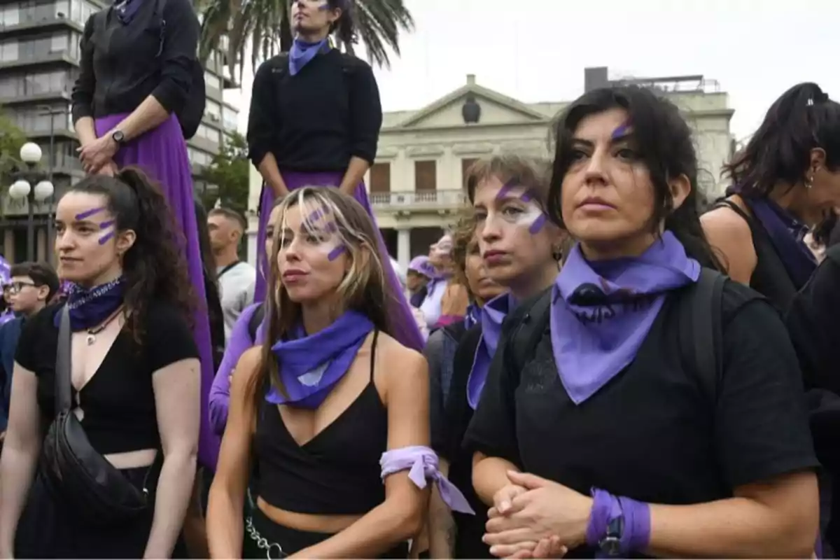 Grupo de mujeres con pañuelos y pintura violeta en el rostro participan en una manifestación feminista al aire libre Grupo de mujeres con pañuelos y pintura violeta en el rostro participan en una manifestación feminista al aire libre