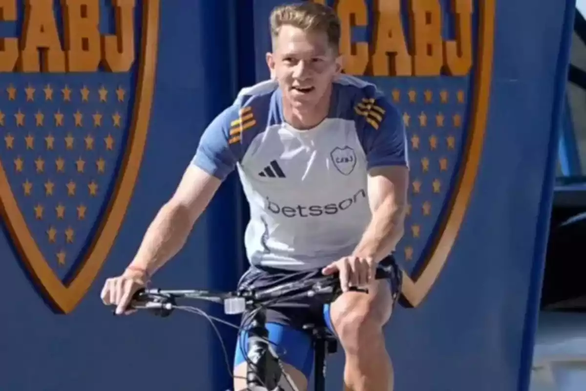 Un hombre con camiseta deportiva de Boca Juniors anda en bicicleta frente a dos escudos grandes del club Un hombre con camiseta deportiva de Boca Juniors anda en bicicleta frente a dos escudos grandes del club