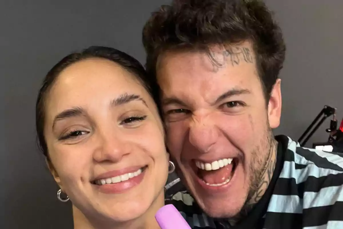 Two people smile and pose together for a selfie, one of them showing a cheerful expression and the other a playful and energetic one. Two people smile and pose together for a selfie, one of them showing a cheerful expression and the other a playful and energetic one.