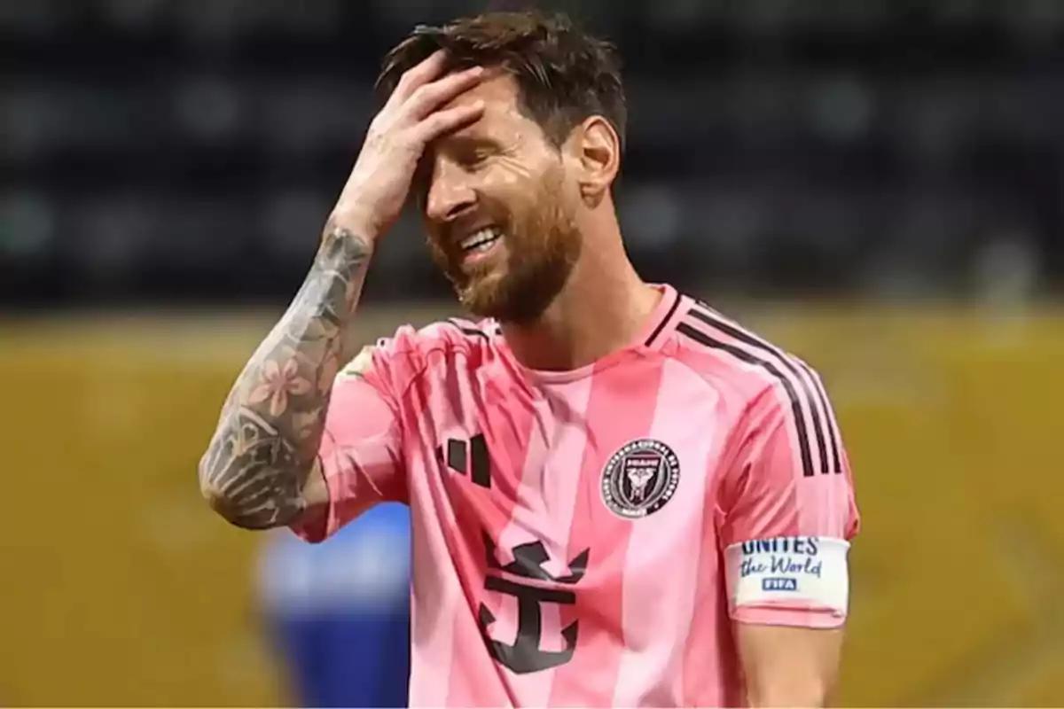 Futbolista con uniforme rosa del Inter Miami llevándose la mano a la cabeza y sonriendo en el campo de juego