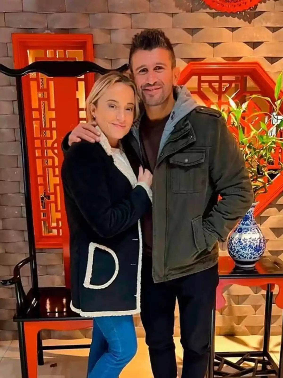 A couple smiles while embracing in a setting decorated with oriental details and warm colors. A couple smiles while embracing in a setting decorated with oriental details and warm colors.