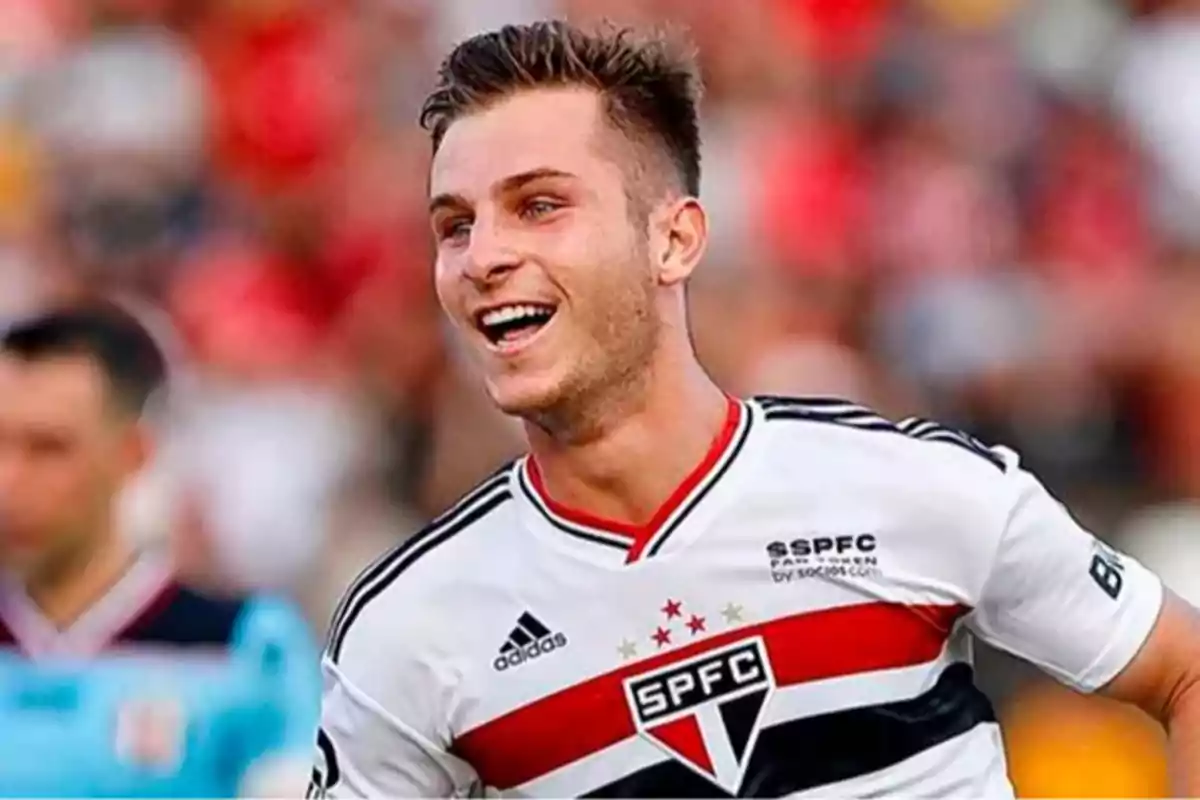Smiling player in a white São Paulo FC uniform during a match Smiling player in a white São Paulo FC uniform during a match
