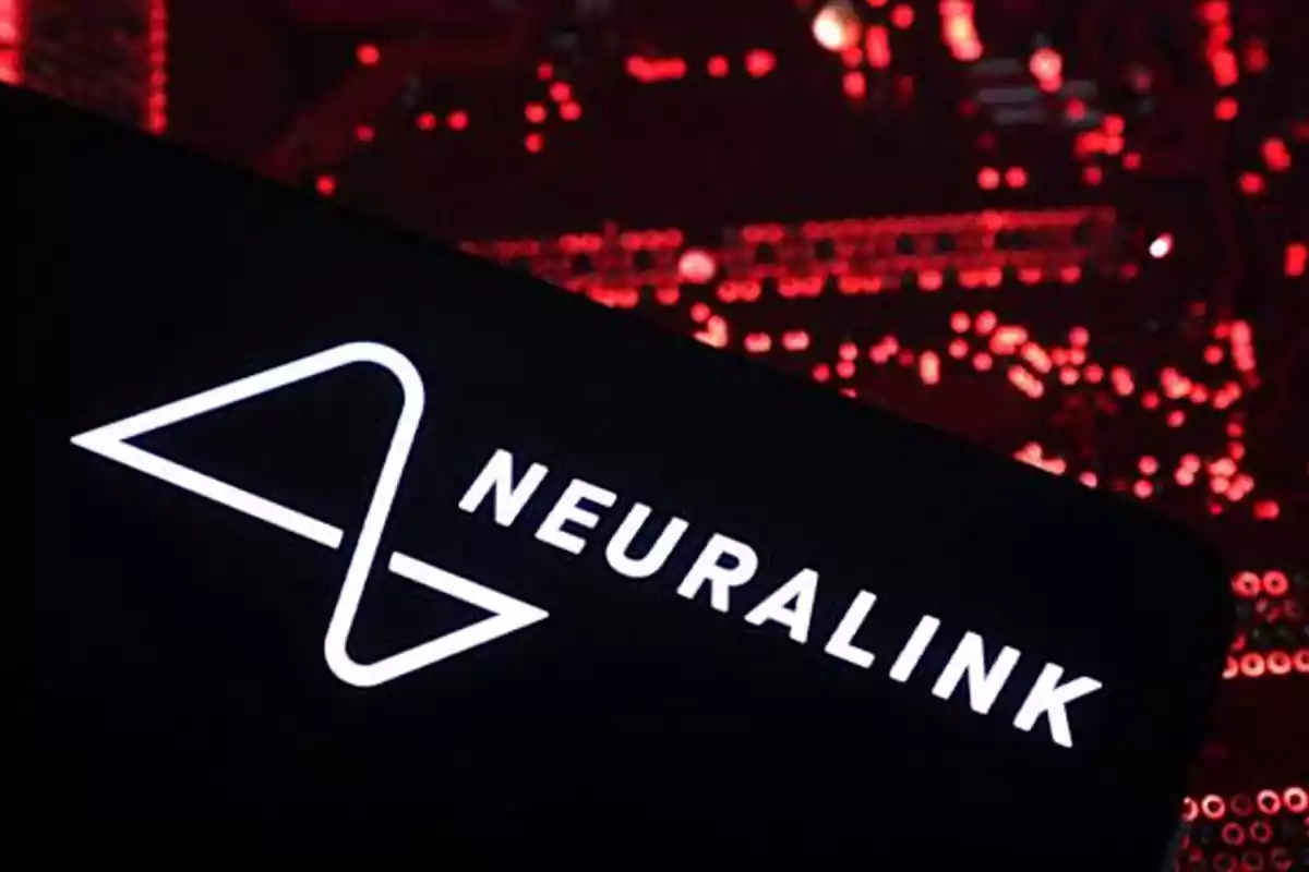 Logo de Neuralink en color blanco sobre un fondo oscuro con luces rojas desenfocadas