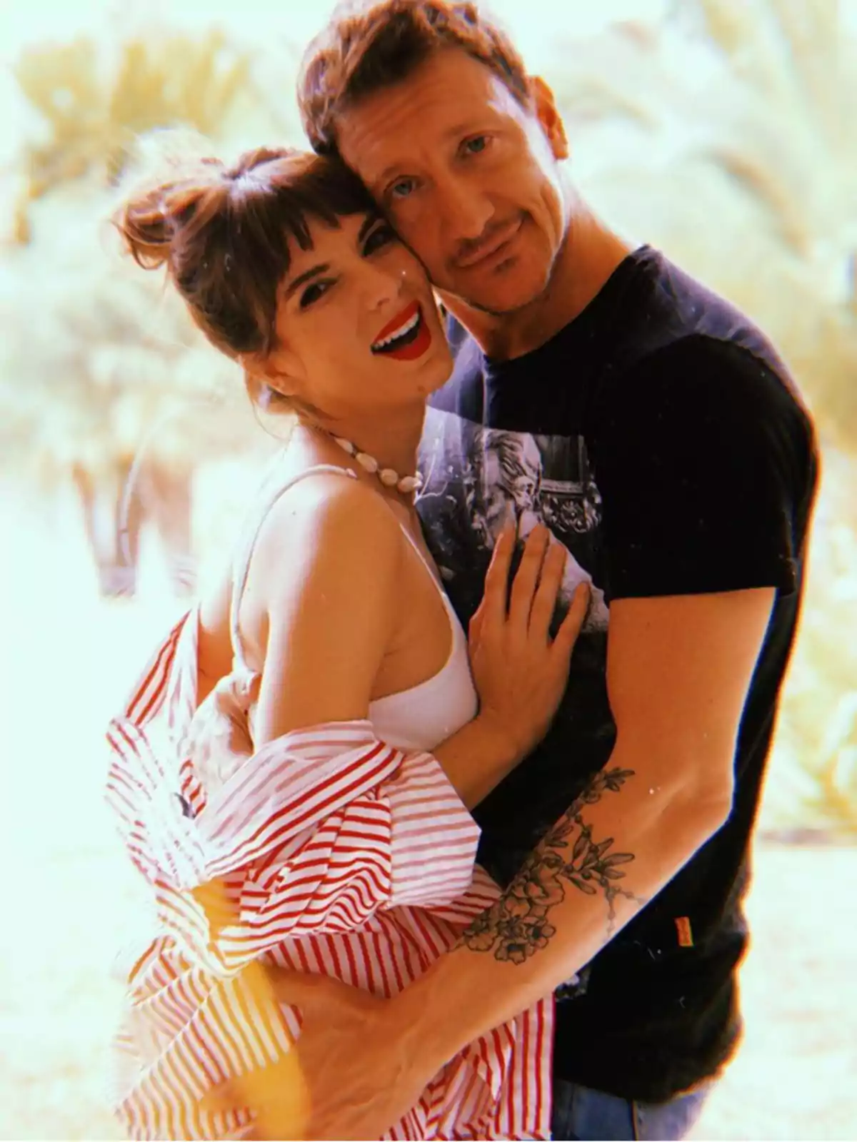 Couple hugging and smiling outdoors with a blurred background and warm light Couple hugging and smiling outdoors with a blurred background and warm light