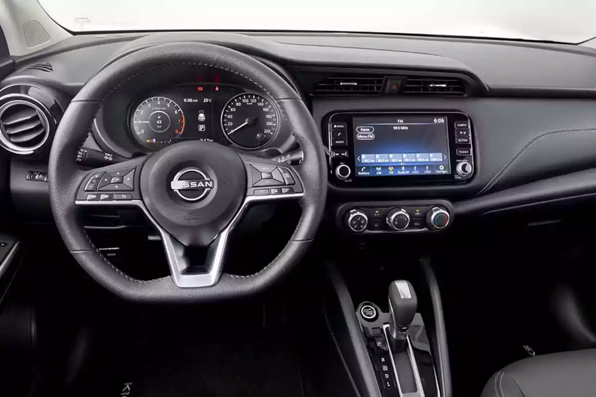 Dashboard of a Nissan car with multifunction steering wheel, central touchscreen, air conditioning controls, and automatic gear lever Dashboard of a Nissan car with multifunction steering wheel, central touchscreen, air conditioning controls, and automatic gear lever