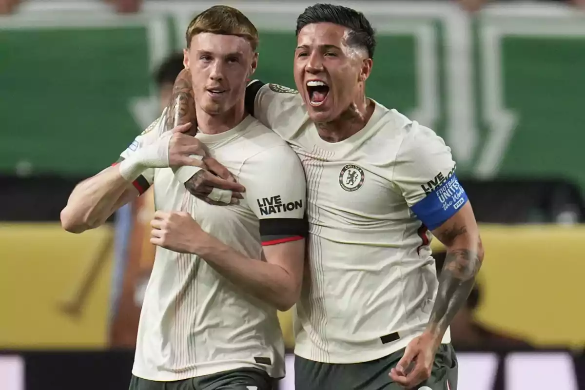 Two players celebrate a goal, hugging and smiling during a match. Two players celebrate a goal, hugging and smiling during a match.