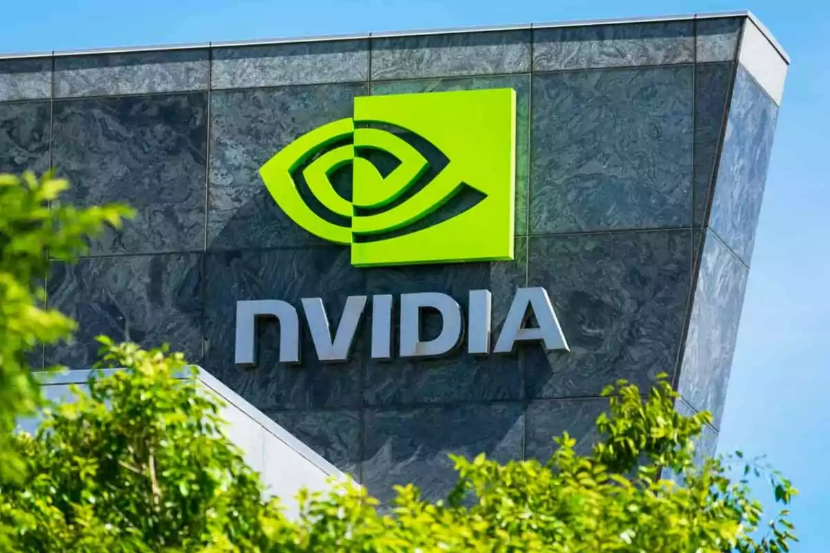 Edificio con el logotipo y nombre de Nvidia en letras plateadas y fondo de mármol, rodeado de vegetación y cielo azul Edificio con el logotipo y nombre de Nvidia en letras plateadas y fondo de mármol, rodeado de vegetación y cielo azul