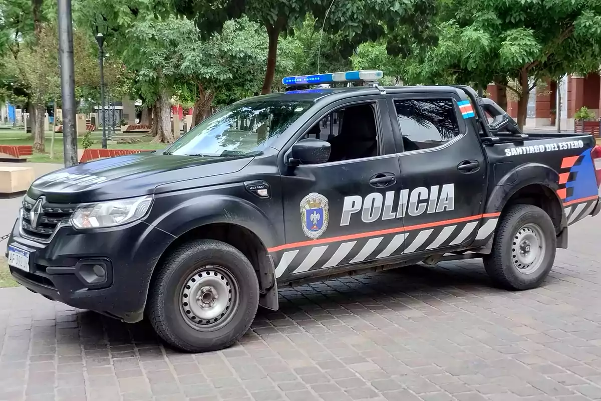 Santiago del Estero police pickup truck parked on a cobblestone street with trees and park benches in the background Santiago del Estero police pickup truck parked on a cobblestone street with trees and park benches in the background