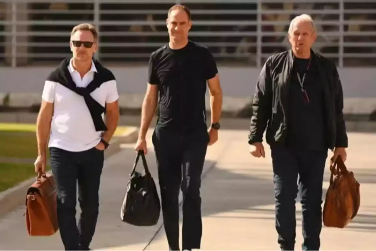 Three men walk together along a sunny sidewalk, each carrying a handbag and wearing casual clothes. Three men walk together along a sunny sidewalk, each carrying a handbag and wearing casual clothes.