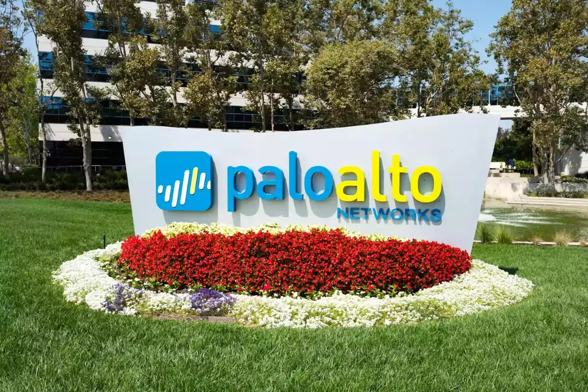 Sign of Palo Alto Networks surrounded by red and white flowers in a garden in front of an office building Sign of Palo Alto Networks surrounded by red and white flowers in a garden in front of an office building